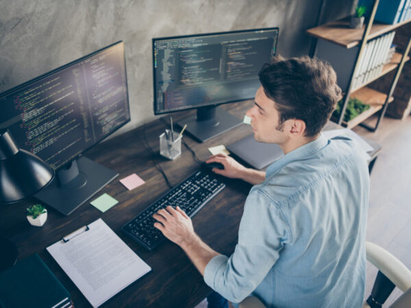 Top above high angle view portrait of his he nice attractive focused skilled geek guy typing bug track report cyberspace security at modern industrial interior style concrete wall work place station